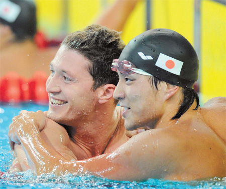 Gold medal winner Ryo Tateishi of Japan (right) celebrates with runner-up Vladislav Polyakov of Kazakhstan at the end of the 100m breaststroke final.