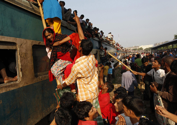 Passengers climb aboard an overcrowded carriage of a train at a railway station in Dhaka, Nov 16, 2010. [China Daily/Agencies]