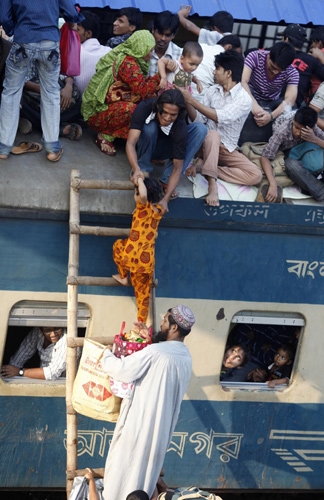 Passengers climb aboard an overcrowded train carriage at a railway station in Dhaka, Nov 16, 2010. [China Daily/Agencies]