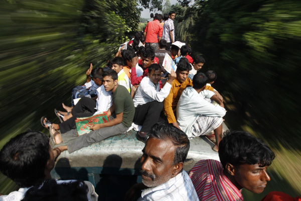 Passengers sit on top of an overcrowded train as it heads for Mymensingh from Dhaka, Nov 16, 2010. [China Daily/Agencies] 