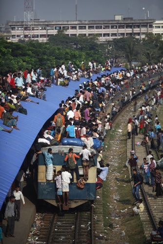 Passengers ride on top of an overcrowded train at a railway station in Dhaka, Nov 16, 2010. [China Daily/Agencies] 