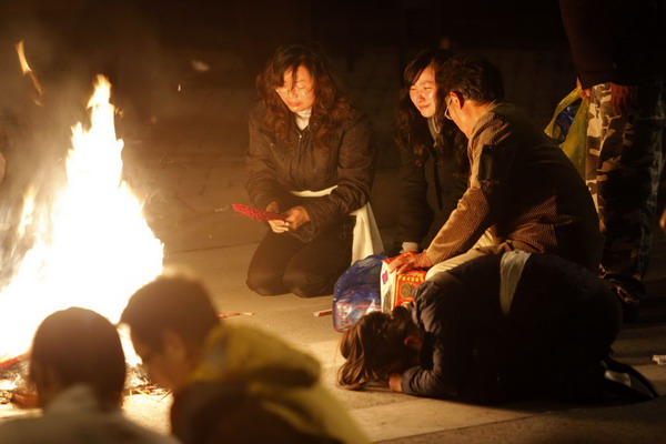 Residents burn the belongings of their relatives who were killed in the apartment fire in Shanghai, Nov 16, 2010.[China Daily/Agencies]