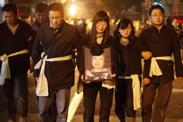 Residents mourn for their relatives at the entrance of the burnt apartment building in Shanghai, Nov 16, 2010. [China Daily/Agencies]