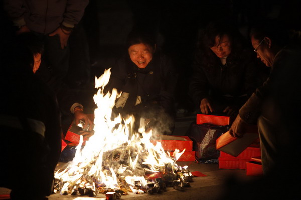 Residents burn the belongings of their relatives who were killed in the apartment fire in Shanghai, Nov 16, 2010. [China Daily/Agencies]