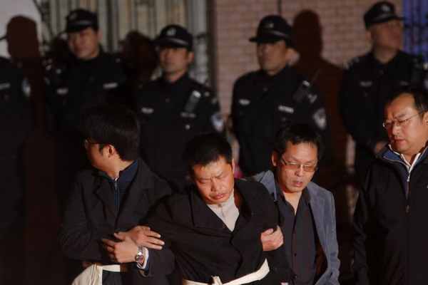 Residents mourn for their relatives at the entrance of the burnt apartment building in Shanghai, Nov 16, 2010. [China Daily/Agencies]