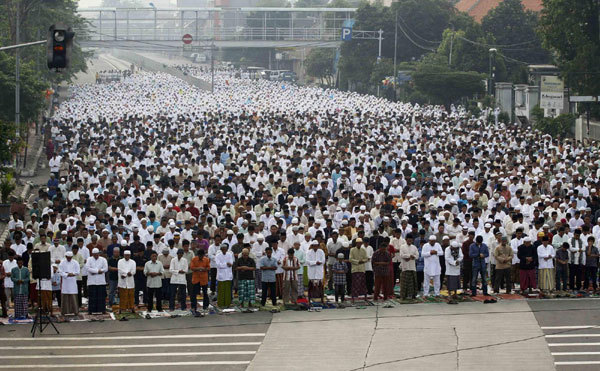 Muslims attend prayer along a street to celebrate the festival of Eid al-Adha in Jakarta Nov 17, 2010. the poor.[China Daily/Agencies]