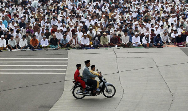 Muslims attend prayer along a street to celebrate the festival of Eid al-Adha in Jakarta Nov 17, 2010. [China Daily/Agencies]