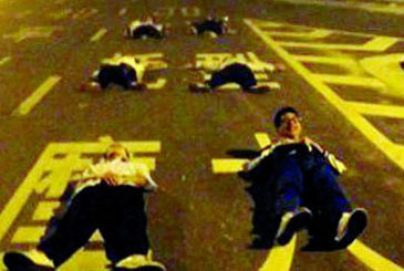 Teens lie in the middle of the road to take souvenir pictures