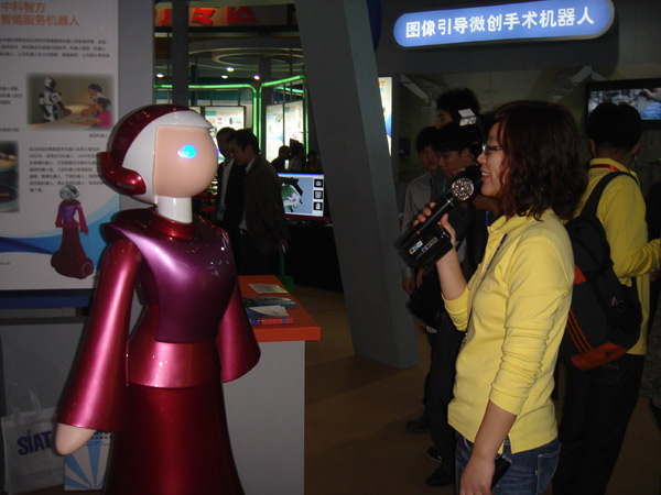 A visitor talks to a guide robot during the hi-tech fair, Nov 16, 2010. [chinadaily.com.cn]