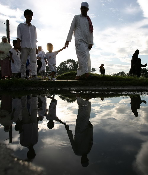 Philipine Muslims pray while washing their hands in preparation for the main Eid al-Adha celebrations at in Manila,the Philippines on November 17, 2010. Muslims around the world celebrate Eid al-Adha to mark the end of the haj by slaughtering sheep, goats, cows and camels to commemorate Prophet Abraham&apos;s willingness to sacrifice his son Ismail on God&apos;s command.[China Daily/Agencies]