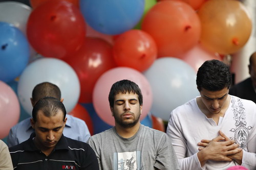 Muslim piligrims pray in the early morning in Cairo,Egypt to celebrations on November 17, 2010. Muslims around the world celebrate Eid al-Adha to mark the end of the haj by slaughtering sheep, goats, cows and camels to commemorate Prophet Abraham&apos;s willingness to sacrifice his son Ismail on God&apos;s command.[China Daily/Agencies]