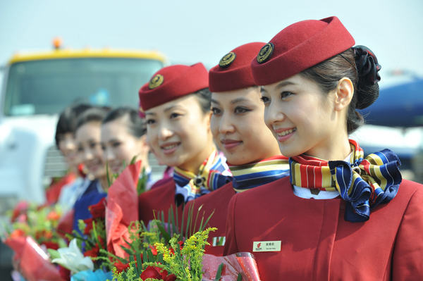 The 8th China International Aviation and Aerospace Exhibition kicks off in Zhuhai City, south China's Guangdong Province, on November 17, 2010. In the picture the top ten model Chinese air hostesses chosen by the Civil Aviation Administration of China present flowers to the stunt pilots of the August 1st Aerobatic Team of the Chinese PLA air force. [Xinhua photo]