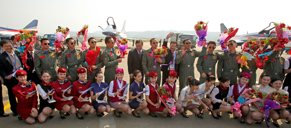 The 8th China International Aviation and Aerospace Exhibition kicks off in Zhuhai City, south China's Guangdong Province, on November 17, 2010. In the picture the top ten model Chinese air hostesses chosen by the Civil Aviation Administration of China present flowers to the stunt pilots of the August 1st Aerobatic Team of the Chinese PLA air force. [Xinhua photo]