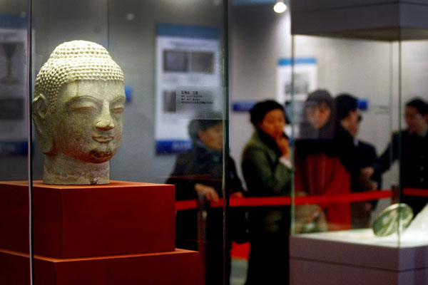 Visitors admire the cultural relics seized from a national crackdown against grave robbery and relics smuggling, which are exhibited at the military museum in Beijing on Wednesday. 