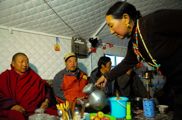 A woman of the Tibetan (Zang) ethnic group makes tea for guests in her tent in Yushu, Qinghai province, Nov 17, 2010. [Xinhua]