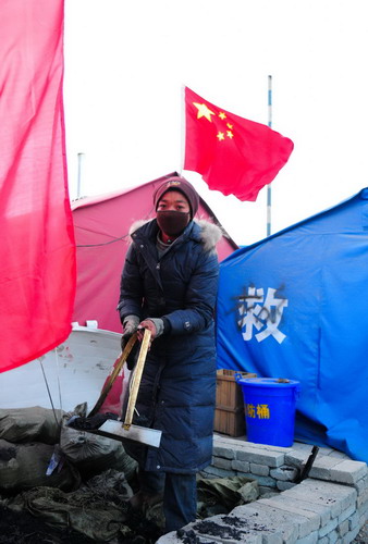 A woman fetches coal in front of a tent in Yushu, Qinghai province, Nov 17, 2010. [Xinhua]