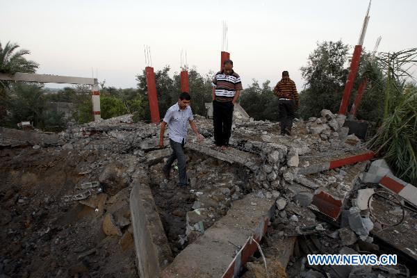 Palestinians inspect a destroyed house after it was hit during Israeli air raid in central Gaza Strip on Nov. 19, 2010. Israeli warplanes conducted three raids against the Gaza Strip Friday, wounding five Palestinians, witnesses and medical sources said. [Wissam Nassar/Xinhua]