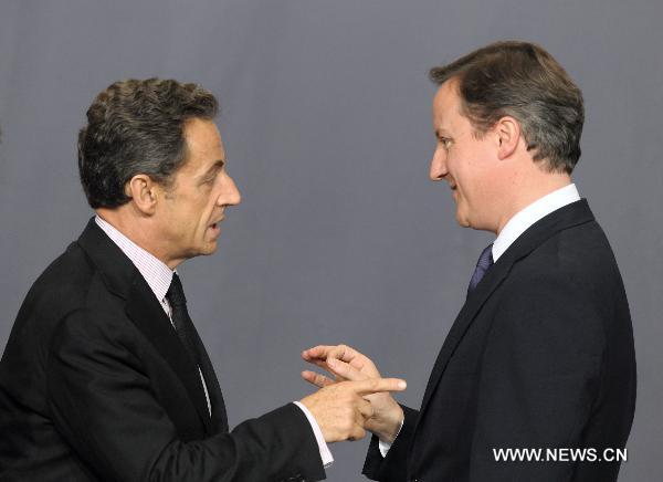 French President Nicolas Sarkozy (L) talks with British Prime Minister David Cameron before posing for a group photo at the venue of the NATO summit in Lisbon, capital of Portugal, Nov. 19, 2010. [Wang Qingqin/Xinhua]