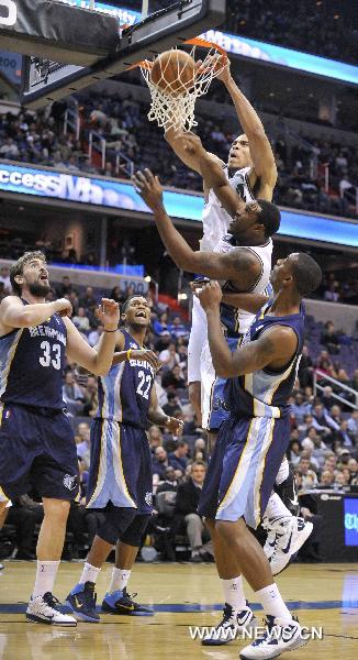 Washington Wizards&apos; JaVale McGee (top) dunks during the NBA basketball games against Memphis Grizzlies in Washington, the United States, Nov. 19, 2010. Wizards won by 89-86. [Zhang Jun/Xinhua]