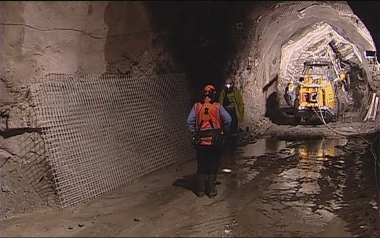 A miner stands next to machinery at a mine in this still image taken from video at Grey District, New Zealand, November 19, 2010. [China Daily/Agencies]