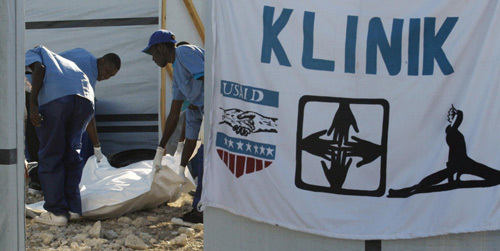 Workers from the Red Cross carry the body of a cholera victim in a make-shift clinic in Port-au-Prince, the capital of Haiti, Nov 20, 2010. [China Daily/Agencies]