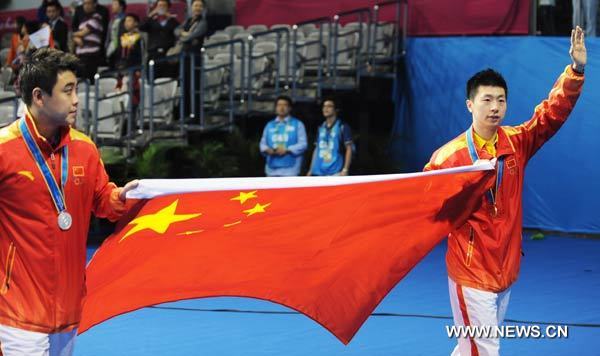 Silver medalist Wang Hao (L) of China and gold medalist Ma Long greet the audience after the men's singles awarding ceremony of table tennis competition at the 16th Asian Games in Guangzhou, south China's Guangdong Province, Nov. 20, 2010. (Xinhua/Xu Jiajun)