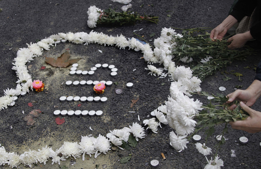 Citizens present flowers to mourn victims of the deadly blaze in Shanghai, east China, Nov. 21, 2010. [Xinhua]