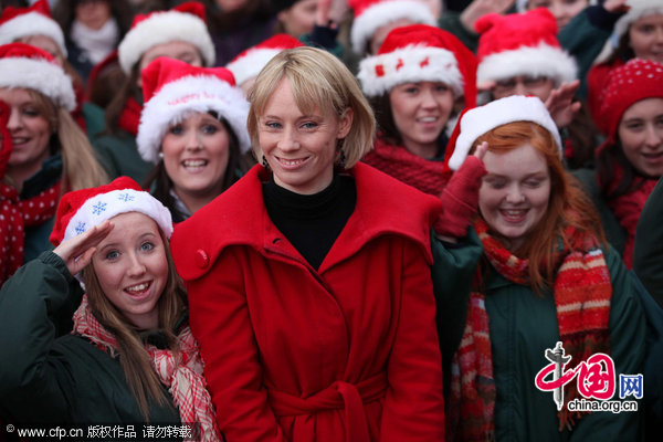 Derval O&apos;Rourke with members of the Ballyphehane Choir from Cork City, as O&apos;Rourke turned on the Christmas lights on Dublin&apos;s Grafton Street. [CFP]