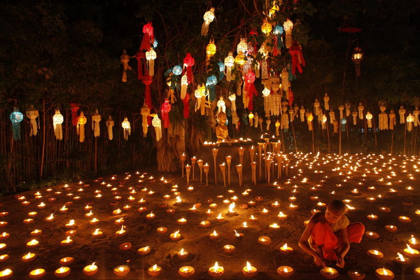 Buddhist monks light candles at a temple in Chiang Mai during the annual Loy Krathong festival November 21, 2010. Celebrated by Thai people around the world, Loy Krathong is an occasion where floral floats are lighted and released at a river as a symbol of good luck and to mark a fresh beginning to life.[China Daily/Agencies]