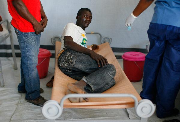 A man suffering from cholera receives treatment in the slum of Cite-Soleil in Port-au-Prince, Haiti, on Nov. 20, 2010. The Haitian Health Ministry said Friday that 76 more people had died from cholera, raising the total number of victims to 1,186 since the first outbreak of the disease detected one month ago in the north of the Haitian capital of Port-au-Prince. [Xinhua]