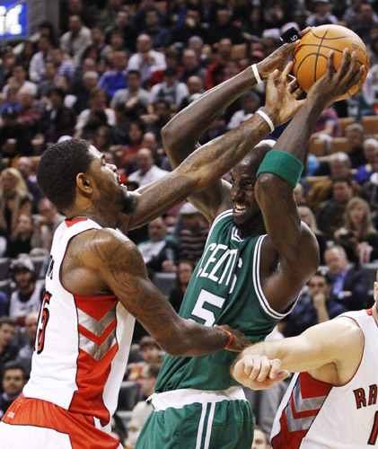 Boston Celtics Kevin Garnett struggles against Toronto Raptors Amir Johnson (L) during the first half of their NBA basketball game in Toronto, November 21, 2010. Raptors won 102-101.(Xinhua/Reuters Photo)