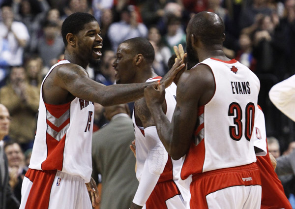 Toronto Raptors Amir Johnson (L) celebrates with Sonny Weems (C) and Reggie Evans after hitting two free throws late in the game against the Boston Celtics during the second half of their NBA basketball game in Toronto, November 21, 2010. (Xinhua/Reuters Photo)