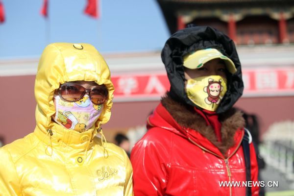 Tourists with face masks walk on the Tian'anmen Square in a clear windy day in Beijing, capital of China, Nov. 21, 2010. Beijing confronted a cold wave on Sunday with temperature predicted to drop to minus three degrees celsius at night. [Xinhua] 