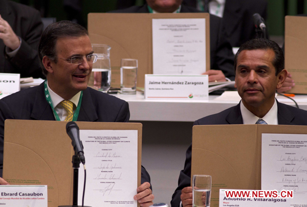 Los Angeles Mayor Antonio Villaraigosa (R) and Mexico City Mayor Marcelo Ebrard display the signed agreements during the World Mayors Summit on Climate Change in Mexico City, Mexico, Nov. 21, 2010. 