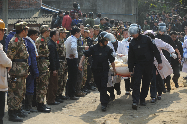 A miner is escorted out of the flooded mine in Weiyuan, Sichuan province, on Monday. Emergency services resuced all 29 men after they were trapped when water inundated the Batian Coal Mine at 11:40 am on Sunday. [Xinhua] 