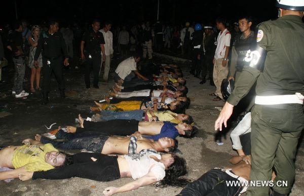 Cambodian Military Police stand near the bodies of the stampede victims in Phnom Penh, Cambodia, Nov. 23, 2010. At least 339 people were killed in a stampede on Monday night as millions of Cambodians celebrated the annual water festival in the capital Phnom Penh, Cambodian Prime Minister Hun Sen said on state TV early Tuesday. The accident took place on a bridge that connects the city with the Diamond Island which has become the center of celebrations. [Xinhua/Phearum]