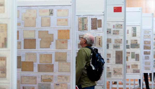 A visitor is attracted by Chinese stamps during the Jerusalem 2010 International Stamp Exhibition, in Jerusalem, on Nov. 22, 2010. 7,000 pages of stamp displays and tens of thousands of philately items, 100 rare stamp collections and unique objects are displayed during the five-day exhibition. [Xinhua photo] 