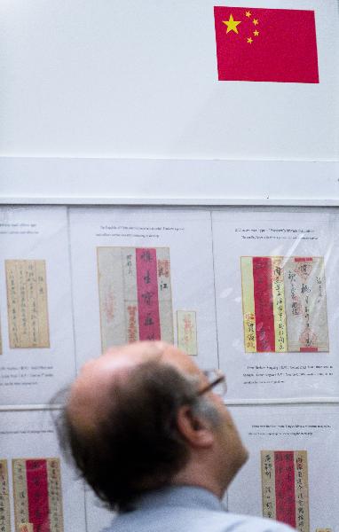 A visitor is attracted by Chinese traditional envelopes during the Jerusalem 2010 International Stamp Exhibition, in Jerusalem, on Nov. 22, 2010. 7,000 pages of stamp displays and tens of thousands of philately items, 100 rare stamp collections and unique objects are displayed during the five-day exhibition. [Xinhua photo] 