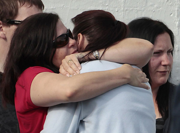 Family members of miners trapped underground in the Pike River coal mine hug as they leave a progress briefing by mine authorities and police in Greymouth on New Zealand&apos;s west coast Nov 23, 2010. [China Daily/Agencies]