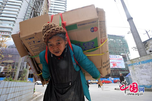 Tan Xiaozhen, 100, carries almost 40kg&apos;s waster paper to salvage station for selling on November 17, 2010 in Guiyang, Guizhou province of China. Tan, has no family and house, lives by collecting waste. 