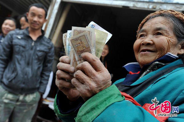 Tan Xiaozhen, 100, shows money after sold her collecting waster at salvage station on November 17, 2010 in Guiyang, Guizhou province of China. [CFP]