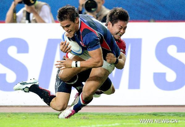 A Japan's player (Back) vies with a player from Hong Kong of China during the men's final of Rugby at the 16th Asian Games in Guangzhou, south China's Guangdong Province, Nov. 23, 2010. Japan won 29-21 and got the gold medal. (Xinhua/Fan Jun) 