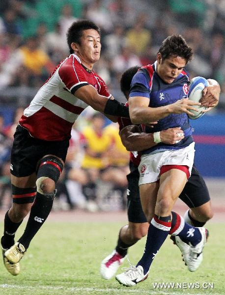 A Japan's player (L) vies with a player from Hong Kong of China during the men's final of Rugby at the 16th Asian Games in Guangzhou, south China's Guangdong Province, Nov. 23, 2010. Japan won 29-21 and got the gold medal. (Xinhua/Fan Jun) 