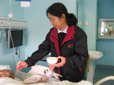 Sister Wang Aixia feeds an AIDS patient at Beijing Ditan Hospital on November 14, 2008.