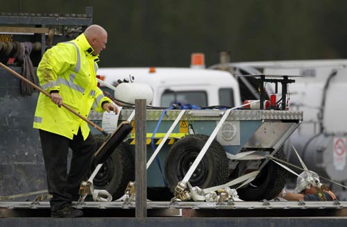 An official cleans a robot from Australia after it was loaded onto a truck at Hokitika airport on New Zealand&apos;s west coast November 24, 2010. The robot will be used to assist the rescue effort of 29 miners trapped underground after an explosion at the nearby Pike River coal mine. [China Daily/Agencies] 