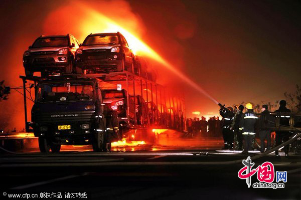 Firefighters extinguish a fire with high-pressure water guns on a highway near Southeast China&apos;s Chongqing municipality on Nov 21. A truck loaded with 20 new cars caught fire at about 9:58 pm while en route to Chongqing. The fire ignited all 20 cars and led to explosions of the cars&apos; tires. The accident blocked traffic on the Yichang-Chongqing highway, but no one was killed.Losses were estimated at nearly 3 million yuan. Authorities are investigating the cause of the fire. [CFP]