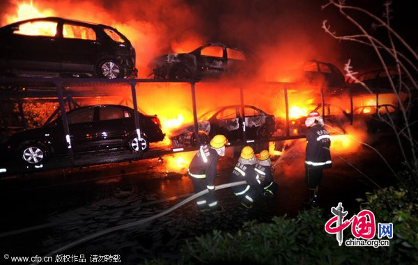 Firefighters extinguish a fire with high-pressure water guns on a highway near Southeast China&apos;s Chongqing municipality on Nov 21. A truck loaded with 20 new cars caught fire at about 9:58 pm while en route to Chongqing. The fire ignited all 20 cars and led to explosions of the cars&apos; tires. The accident blocked traffic on the Yichang-Chongqing highway, but no one was killed.Losses were estimated at nearly 3 million yuan. Authorities are investigating the cause of the fire. [CFP]