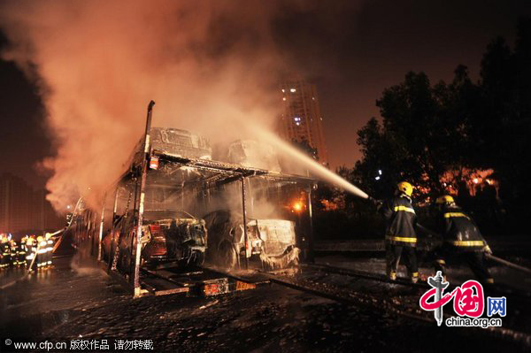 Firefighters extinguish a fire with high-pressure water guns on a highway near Southeast China&apos;s Chongqing municipality on Nov 21. A truck loaded with 20 new cars caught fire at about 9:58 pm while en route to Chongqing. The fire ignited all 20 cars and led to explosions of the cars&apos; tires. The accident blocked traffic on the Yichang-Chongqing highway, but no one was killed.Losses were estimated at nearly 3 million yuan. Authorities are investigating the cause of the fire. [CFP]