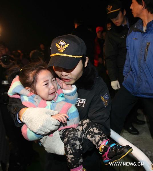 A police officer carries a terrified child on the Yeonpyeong Island hit by artillery shells the Democratic People&apos;s Republic of Korea (DPRK) fired a day ago, Nov. 24, 2010. South Korea and the DPRK on Tuesday exchanged fires in waters off the west coast of the divided Korean Peninsula, near the contentious sea border called Northern Limit Line (NLL). [Xinhua]