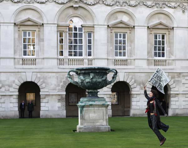 A demonstrator runs through the grounds of Senate House at Cambridge University, in Cambridge eastern England November 24, 2010. [Xinhua/Reuters]